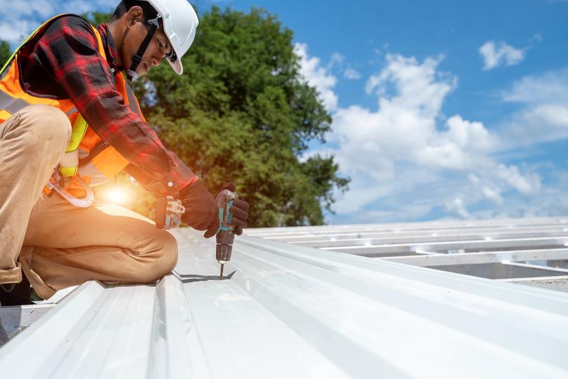 A roofer installing a new roof on a house