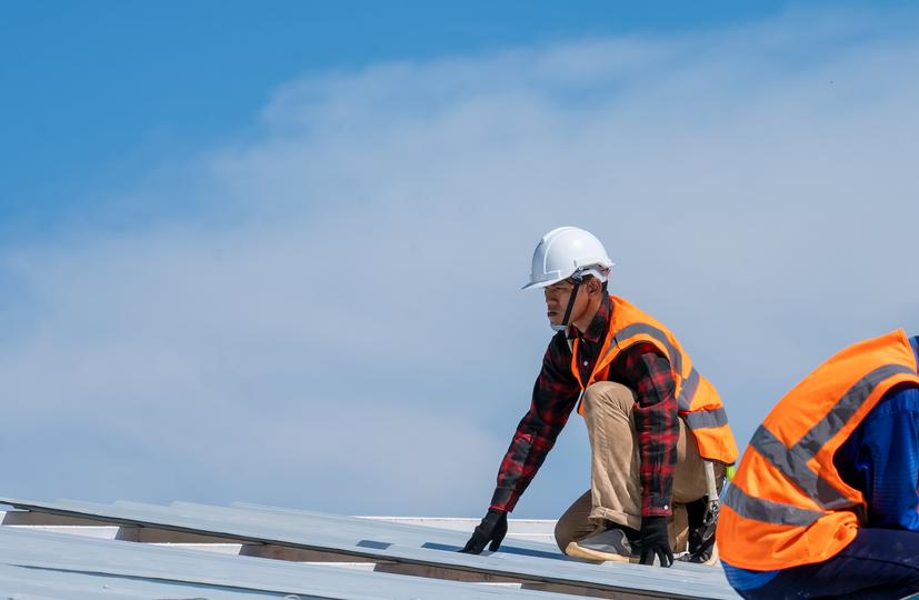 A roofer installing a new roof on a house