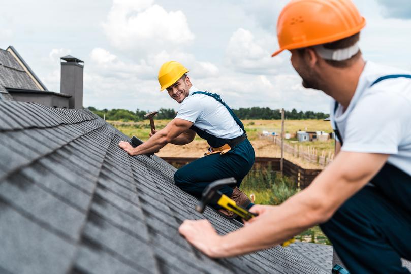 A roofer installing a new roof on a house